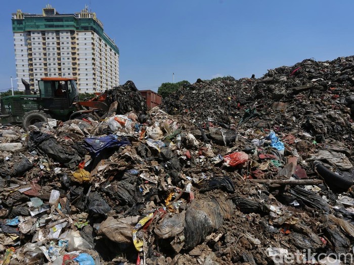 Petugas mengangkut gunungan sampah di Tempat Pembuangan Sampah (TPS) illegal di Jl Kepanduan II, Penjaringan, Jakarta Utara, Senin (27/7/2026). Truk sampah hilir mudik hingga 20 truk sampah per hari. Bau menyengat tercium hingga radius 50 meter tergantung arah angin. Menurut sejumlah warga, lokasi tersebut awalnya merupakan bagian dari ruang terbuka hijau (RTH) namun dimanfaatkan pihak swasta untuk pembuangan sampah hingga banyak pemulung mendirikan gubuk liar untuk mengumpulkan barang bekas. Setelah sampah dibersihkan, lokasi ini akan menjadi RTH kembali.