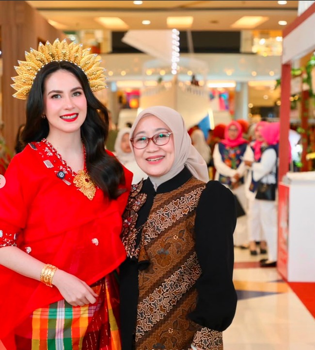 Baju bodo merah tersebut dipadukan dengan kain bermotif kotak-kotak berwarna kuning, hijau, merah, hingga ungu. Kombinasi warna yang berani ini memberikan kesan ceria sekaligus memperkaya nuansa budaya pada penampilannya. Foto: Instagram/@arumibachsin_94
