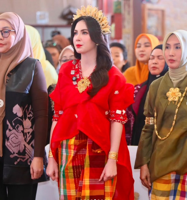 Arumi melengkapi tampilannya dengan bros berukuran besar pada bagian dadanya, gelang emas di kedua pergelangan tangan, serta anting senada yang tidak mencolok. Seluruh perhiasan tersebut memberikan sentuhan glamor tanpa terlihat berlebihan. Foto: Instagram/@arumibachsin_94