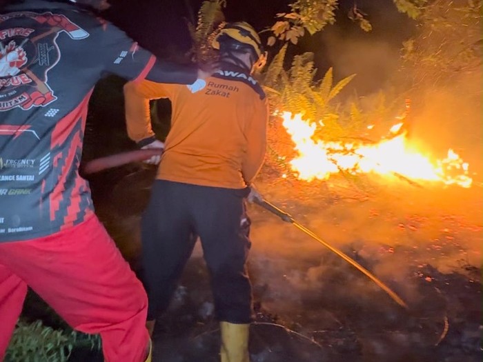 Petugas dan relawan sedang padamkan api yang membakar lahan gambut di Pontianak. (dok Istimewa)
