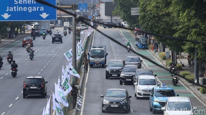 Petugas Satpol PP mencabut atribut partai politik yang terpasang di pagar median Jalan Sutomo, Pasar Baru, Jakarta Pusat, Selasa (28/7/2026). Penertiban dilakukan karena atribut tersebut masih terpasang setelah kegiatan partai berakhir.