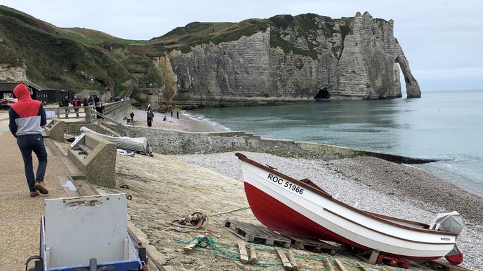 15 November 2024, France, Etretat: Beach and promenade with a view of the chalk cliffs of Etretat. The chalk cliffs attract almost 1.5 million visitors every year. With the exception of the beach on the Etretat promenade, the beaches on the chalk cliffs will be closed to visitors in future. Access is now prohibited to prevent fatal accidents and rockfalls. Photo: Michael Evers/dpa (Photo by Michael Evers/picture alliance via Getty Images)