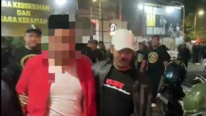 Yakuza Maneges membawa guru ngaji ponpes di Kota Malang yang diduga cabuli santri laki-laki ke Polresta Malang Kota.