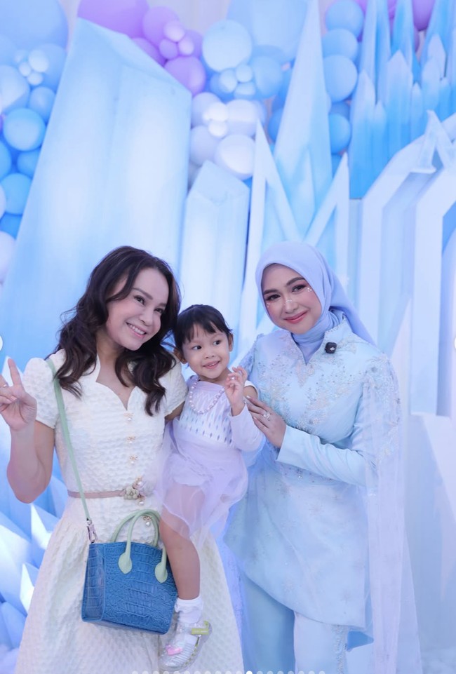 Rossa bersama putri angkatnya, Raina, juga terlihat hadir. Rossa tampil cantik kenakan dress kuning pastel. Foto: Instagram/@riaricis1795