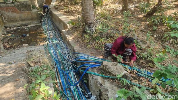 Warga Kalidadap I, Selopamioro, Imogiri, Bantul menyedot air dari Sendang Wonosari dengan selang untuk memenuhi kebutuhan air bersih di rumahnya, Rabu (29/7/2026).