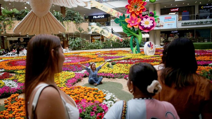 People pose for a photo at the Tapete de Flores floral installation at Santafe shopping mall ahead of Medellin’s annual Flower Festival, in Medellin, Colombia, July 29, 2026. REUTERS/Juan David Duque