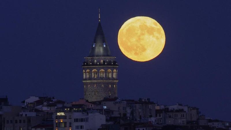 A full moon rises behind the Galata Tower in Istanbul, Turkey, July 29, 2026. REUTERS/Dilara Senkaya     TPX IMAGES OF THE DAY