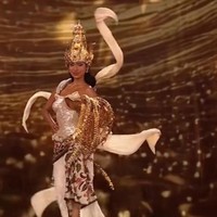 Gaun rancangan desainer Dibba ini menghadirkan siluet menyerupai kemben modern berwarna putih mutiara dengan efek berkilau, dipadukan kain batik bermotif flora yang menjuntai hingga lantai. Foto: Instagram/@misssupranational