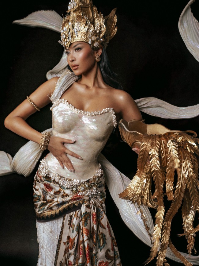 Bagian paling mencuri perhatian adalah mahkota berwarna emas rancangan Rinaldy A. Yunardi. Headpiece berukuran besar itu dihiasi detail bunga, dedaunan, dan ornamen menyerupai bulir padi yang menjulang tinggi, memperkuat kesan agung layaknya seorang dewi. Foto: Instagram/@officialputeriindonesia