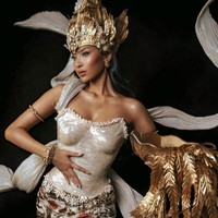 Bagian paling mencuri perhatian adalah mahkota berwarna emas rancangan Rinaldy A. Yunardi. Headpiece berukuran besar itu dihiasi detail bunga, dedaunan, dan ornamen menyerupai bulir padi yang menjulang tinggi, memperkuat kesan agung layaknya seorang dewi. Foto: Instagram/@officialputeriindonesia