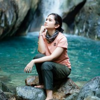 Pose di bawah air terjun, Tissa tampil santai. Ia duduk sambil bertopang dagu di atas tumpukan bebatuan. Foto: Instagram/@tissabiani