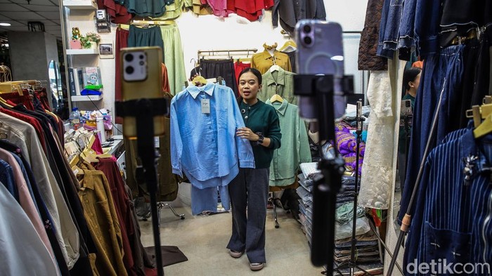 Pedagang melakukan siaran langsung untuk menjual produk di Pasar Tanah Abang, Jakarta Pusat, Kamis (30/7/2026). Live shopping menjadi salah satu strategi memperluas pasar melalui platform e-commerce.