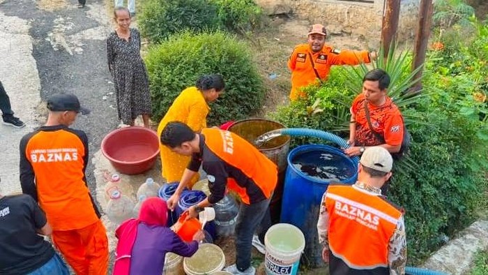 Puluhan warga Kampung Tegalmalang, Desa Cintalanggeng, Kecamatan Tegalwaru, Kabupaten Karawang saat antre air bersih yang dikirim BPBD Karawang