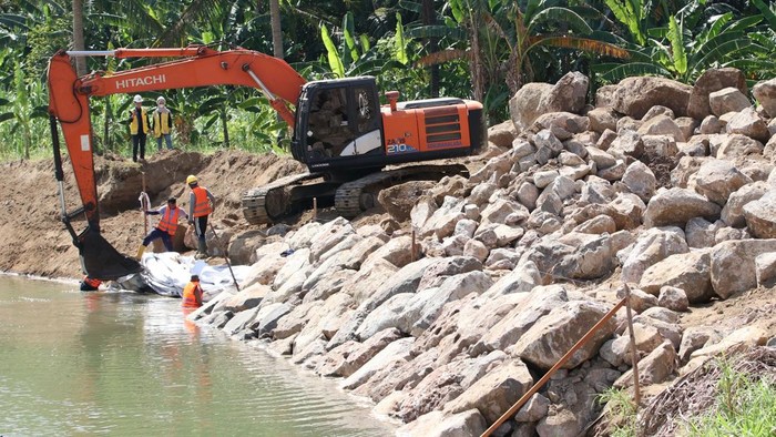 Pekerja memasang geotekstil (kain filter) dengan bantuan alat berat pada pembangunan tanggul Sungai Krueng Aceh di Kabupaten Aceh Besar, Aceh, Kamis (30/7/2026). Balai Wilayah Sungai Sumatera I melakukan pemasangan batu boulder (batu gajah) sebagai upaya memperkuat tebing Sungai Krueng Aceh guna mengurangi risiko abrasi, meningkatkan kapasitas pengendalian banjir, serta melindungi kawasan di sepanjang aliran sungai di Aceh Besar. ANTARAFOTO/Akramul Muslim/agr