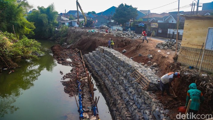Pekerja menyelesaikan proyek pembangunan turap bronjong di bantaran Kali Angke, Pamulang, Tangsel, Jumat (31/7/2026).