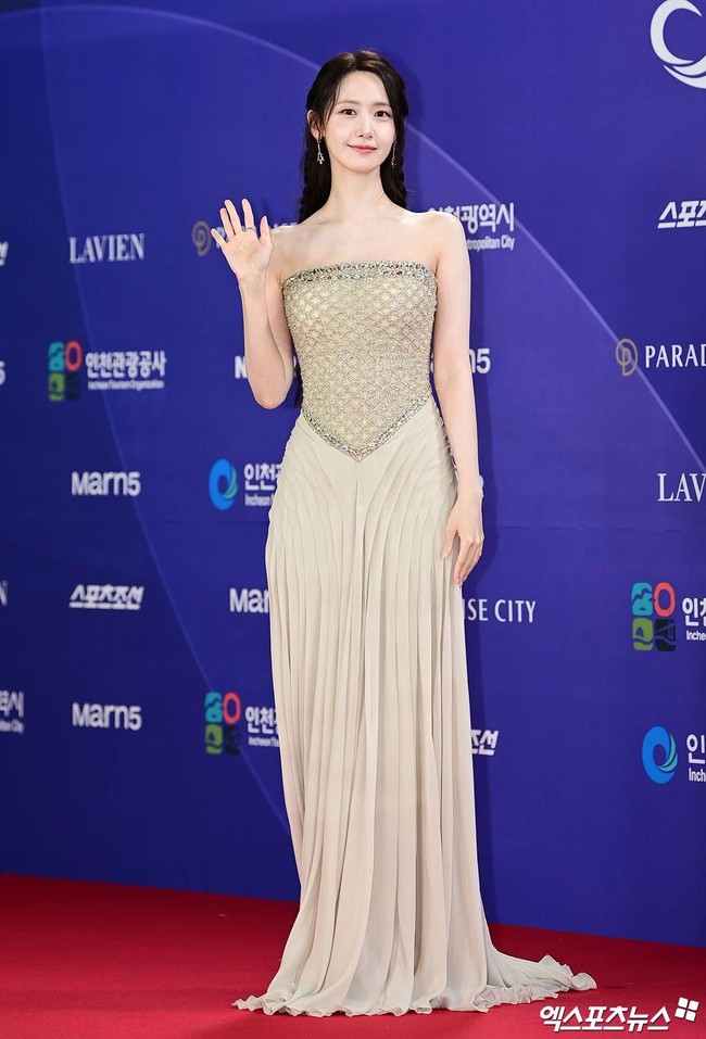 Yoona tampil memukau sebagai pemandu acara Blue Dragon Series Awards 2026. Saat tiba di red carpet, personel SNSD itu memancarkan pesonanya dalam balutan gaun tanpa tali dengan atasan berbahan tulle berhiaskan manik-manik, dilengkapi dengan rok yang menyapu lantai. Rambutnya dikepang menjadi dua sisi, memperlihatkan kemewahan anting-anting berlian bermata ruby dari Qeelin. Foto: Instagram