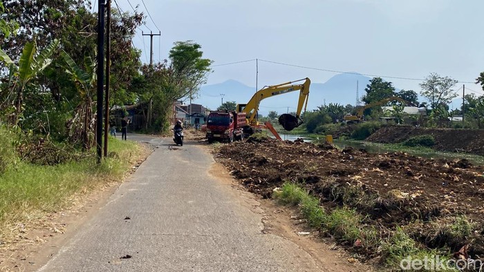 Alat berat melakukan pengerukan sedimentasi di Sungai Cikeruh.