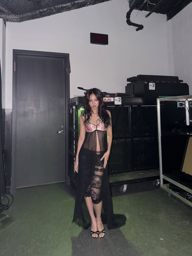 Vokalis ‘Like Jennie’ tersebut mengenakan atasan serupa bralette pink dengan sayap material flowy. Atasan itu dipadukan celana renda hitam yang juga menerawang. Foto: Instagram @jennierubyjane