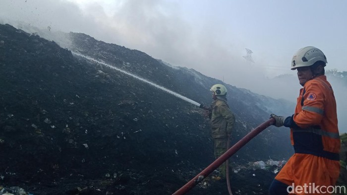 Tim Damkar Klaten memadamkan api di TPA Troketon, Pedan, Klaten.