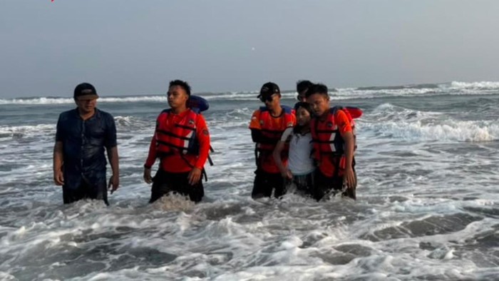 Petugas saat mengevakuasi remaja perempuan (kaus putih) yang hanyut saat bermain air di Pantai Parangtritis, Kretek, Bantul, Minggu (2/8/2026).