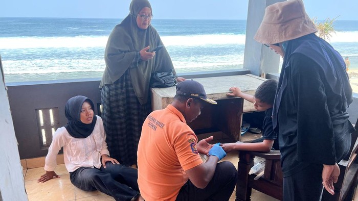 Tim SAR saat menangani anak-anak yang tersengat ubur-ubur saat bermain di pantai selatan Gunungkidul, Minggu (2/8/2026).
