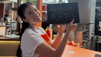 Tyna Dwi Jayanti tampak tersenyum sambil memegang papan bertuliskan restock 2:30. Hal itu menunjukkan betapa dagangannya begitu laku. (Foto: dok Instagram tynadwijayanti)