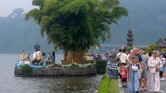 Wisatawan mancanegara berpose mengenakan busana pengantin adat Bali saat berkunjung di Daya Tarik Wisata (DTW) Ulun Danu Beratan, Tabanan, Bali, Senin (3/8/2026). Badan Pusat Statistik Provinsi Bali mencatat jumlah kunjungan wisatawan mancanegara yan
