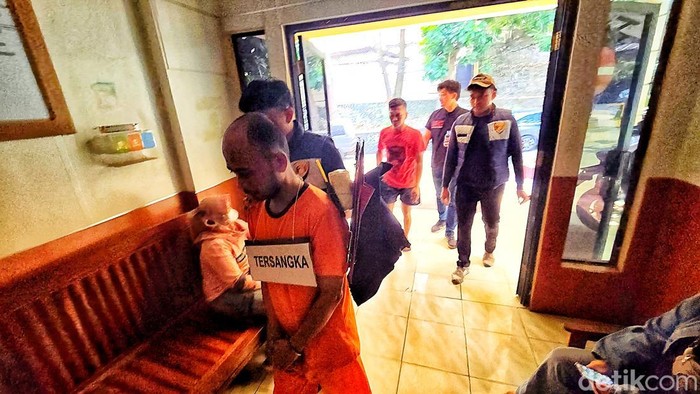Delon tertunduk dengan tangan terborgol usai menjalani proses rekontruksi