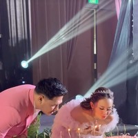 Senada dengan busana kedua mempelai, kue pernikahan dibuat memanjang dengan dominasi warna pink. Di bagian atasnya terdapat lilin-lilin yang dinyalakan untuk ditiup oleh Joanna dan Chris. Foto: Instagram/@joannaalexandra