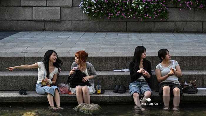 Orang-orang ngadem di Sungai Cheonggyecheon di Seoul. (Jade Gao/AFP)