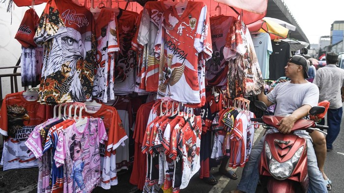 Calon pembeli melihat kaos bertema kemerdekaan yang dijual di Pasar Asemka, Jakarta, Minggu (2/8/2026). Menurut sejumlah pedagang, penjualan pernak-pernik HUT ke-81 RI mulai dari bendera Merah-Putih, busana, aksesoris, hingga hiasan dekorasi mengalami peningkatan sebesar 20 persen sejak akhir Juli dengan harga jual dari Rp5ribu sampai Rp350 ribu. ANTARA FOTO/Muhammad Adimaja/sgd
