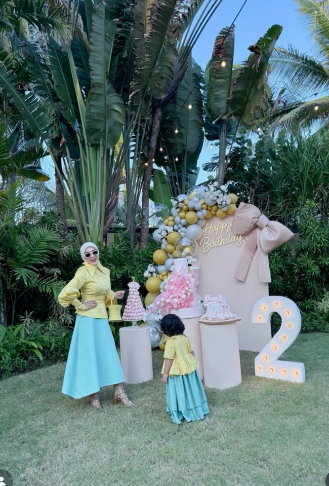 Syahrini terlihat baru saja merayakan ulang tahun putrinya yang ke-2. Berlokasi outdoor, dekorasi bernuansa pink nude dihiasi balon-balon berwarna kuning mustard dan abu-abu tampak sudah dipersiapkan. Foto: Instagram/@princessyahrini