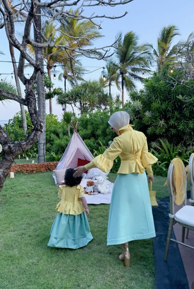 Syahrini dan putrinya, Baby Princess R tampil kembar kenakan atasan berwarna kuning dipadukan dengan rok panjang warna hijau turquoise. Sayangnya hingga kini wajah sang putri masih dirahasiakan. Foto: Instagram/@princessyahrini