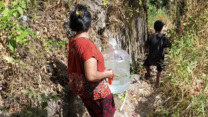 Warga berjalan kaki naik turun bukit mencari air untuk mandi.