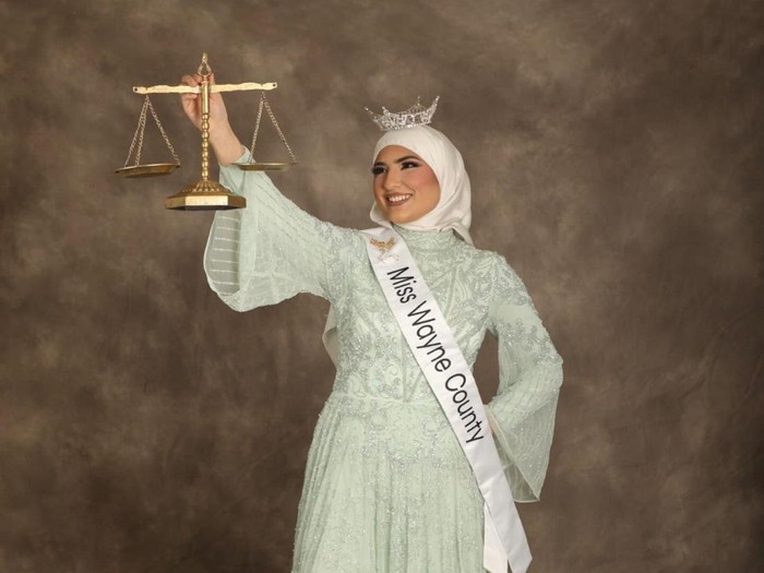 Ameera Hashwi, pengacara berhijab pertama pemenang Miss Wayne County 2025, menyapa publik di parade Dearborn seraya menyuarakan kesetaraan hak bagi para perempuan.