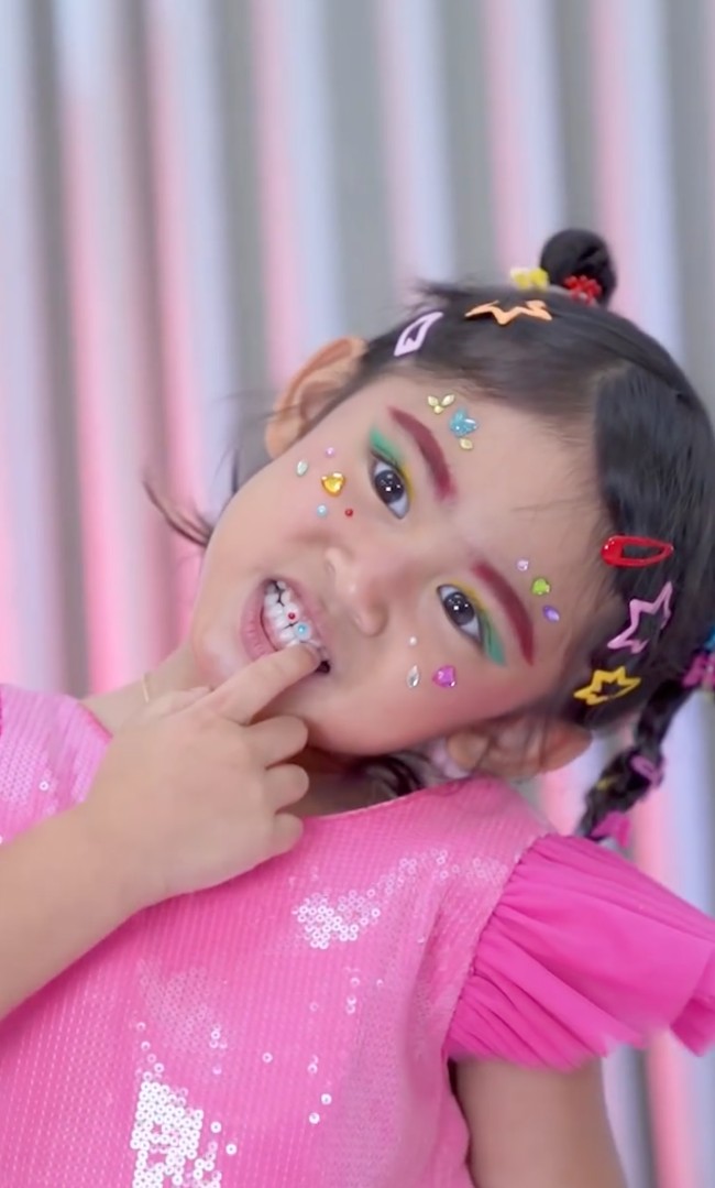 Putri semata wayang Ria Ricis, Moana, ikut meramaikan tren makeup ala Naykilla. Totalitas, Moana tak hanya meniru gaya rambut dan makeup Naykilla, melainkan juga tooth gems di mulutnya. Foto: Instagram