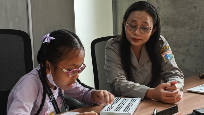 Aparatur Sipil Negara (ASN) Dispusip (kanan) mengamati seorang warga yang  belajar menulis huruf braille di Perpustakaan Jakarta, Taman Ismail Marzuki, Jakarta, Selasa (4/8/2026). Dispusip DKI Jakarta menggelar pelatihan membaca dan menulis braille secara gratis setiap tanggal 4 setiap bulan untuk memperluas akses literasi bagi masyarakat. ANTARA FOTO/Fakhri Hermansyah