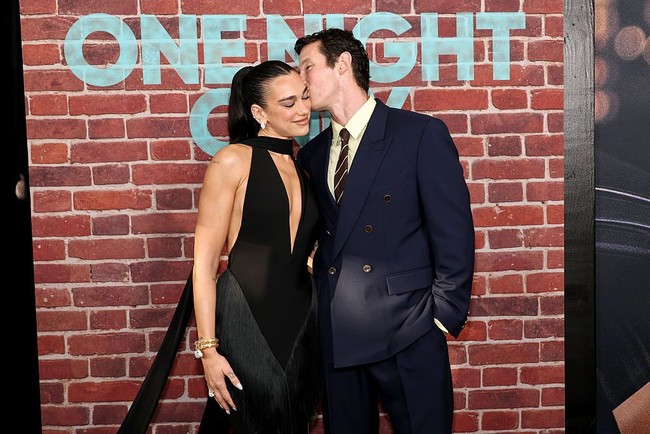 Aktor Callum Turner mengenakan setelan jas double-breasted berwarna navy, dipadukan kemeja kuning pucat dan dasi cokelat bergaris. Foto: Getty Images/Jamie McCarthy