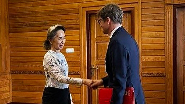 Mantan pemimpin Myanmar Aung San Suu Kyi berjabat tangan dengan seorang pejabat Komite Internasional Palang Merah (ICRC). (Myanmar Military Information Committee)