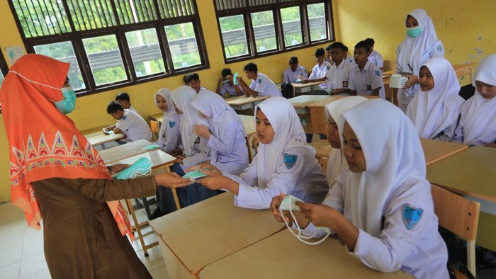 Petugas kesehatan dari Pukesmas Samatiga membagikan masker kepada pelajar di Sekolah Menengah Kejuruan Negeri (SMKN) 1 Samatiga, Aceh Barat, Aceh, Senin (3/8/2026). Aksi pembagian masker tersebut dilakukan untuk mengantisipasi penyakit infeksi saluran pernafasan akut (ISPA) dampak kabut asap yang ditimbulkan oleh kebakaran hutan dan lahan (karhutla) yang semakin meluas di kabupaten setempat. ANTARA FOTO/Syifa Yulinnas/nym.