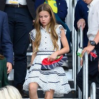 Charlotte mengenakan gaun putih beraksen ruffle dari Guess Kids. Motif polka dot dan garis-garis navy mempermanis penampilannya. Foto: WireImage/Karwai Tang