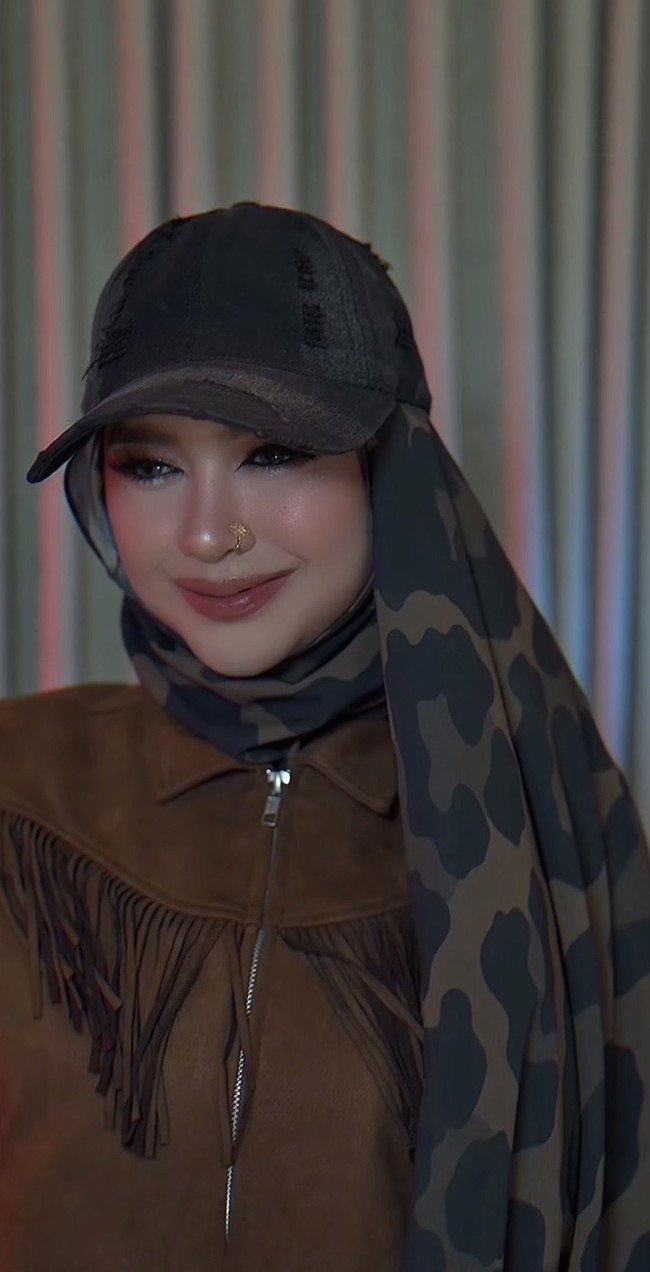 Salah satu detail yang paling mencolok adalah aksesori anting hidung berwarna emas berbentuk melingkar kecil. Aksesori ini semakin memperkuat kesan edgy pada penampilannya. Foto: Instagram/@riaricis1795