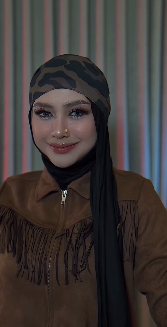Untuk penutup kepala, Ria Ricis memilih hijab bermotif loreng bernuansa hijau, cokelat, dan hitam yang dipadukan dengan inner hitam polos. Dalam beberapa foto, Ricis juga tampak menggunakan topi hitam yang senada dengan hijabnya. Foto: Instagram/@riaricis1795