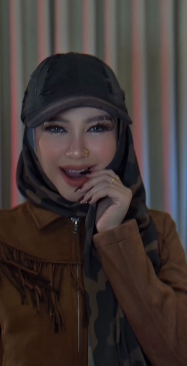 Ricis mengenakan jaket berbahan suede berwarna cokelat dengan detail rumbai panjang di bagian dada. Penampilannya itu pun langsung banjir komentar. “Cantik dan pangling banget buicissssssss,” tulis salah satu komentar. “Kali ini kerennn bnr,” komentar lain. Foto: Instagram/@riaricis1795