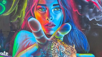 Neon Jungle karya Luisfer Guarín di Comas, Peru, menghadirkan sosok perempuan dan jaguar berwarna-warni yang tampak keluar dari dinding. Karya ini dibuat dalam festival mural internasional GREENGRAFF di Lima. Foto: via StreetArtUtopia