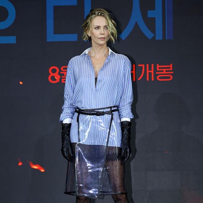 Gaya Charlize Theron Pamer Kaki Jenjang Pakai Rok Plastik Transparan