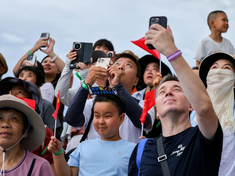 WENCHANG, CHINA - AUGUST 04: Spectators watch as a Long March-8A carrier rocket, carrying the 23rd group of the low-orbit internet constellation, blasts off from the Hainan commercial spacecraft launch site on August 4, 2026 in Wenchang, Hainan Province of China. China sent a new batch of internet satellites into orbit on August 4 in the southern island province of Hainan. The satellites lifted off aboard a Long March-8A carrier rocket at 4:52 p.m. (Beijing Time) and entered their preset orbits successfully. (Photo by Luo Yunfei/China News Service/VCG via Getty Images)