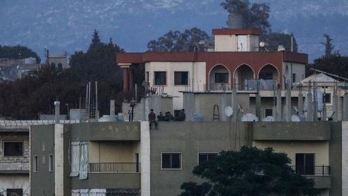 A photograph taken from the southern Lebanese village of Zawtar al-Gharbiyah, one of the first pilot zones, shows Israeli soldiers standing on the roof of a residential building in the nearby village of Zawtar al-Charkiyah, on August 4, 2026. Lebanon