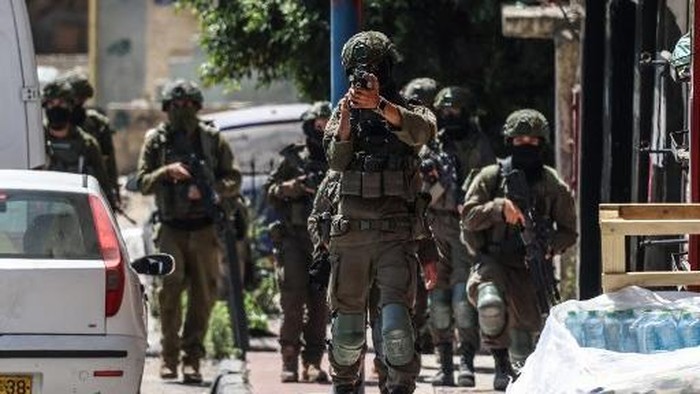 A member of the Israeli security forces aims his weapon while patrolling along a street during a military raid in the Qalandia refugee camp, south of Ramallah in the Israeli-occupied West Bank, on August 5, 2026. Since the start of the Gaza war in Oc
