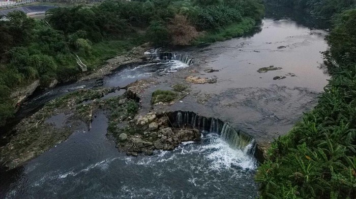 Foto udara aliran kali Bekasi yang berbusa dan bewarna hitam diduga akibat tercemar limbah di kawasan Margahayu, Kota Bekasi, Jawa Barat, Rabu (5/8/2026). Dinas Lingkungan Hidup Kota Bekasi menyatakan hasil pemantauan dan uji laboratorium menunjukkan kualitas air Sungai Cileungsi hingga Kali Bekasi melampaui baku mutu lingkungan akibat tingginya kadar Total Suspended Solids (TSS), Biochemical Oxygen Demand (BOD), logam berat, dan fecal coliform, sehingga memerlukan penanganan terpadu bersama pemerintah pusat, Pemerintah Provinsi Jawa Barat, dan Pemerintah Kabupaten Bogor. ANTARA FOTO/Darryl Ramadhan/
